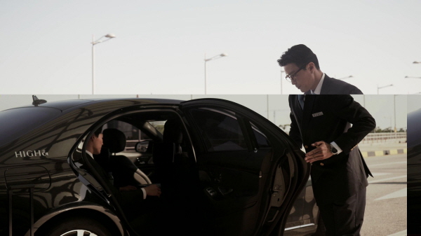 고급차량에서 차 문을 열어주는 기사