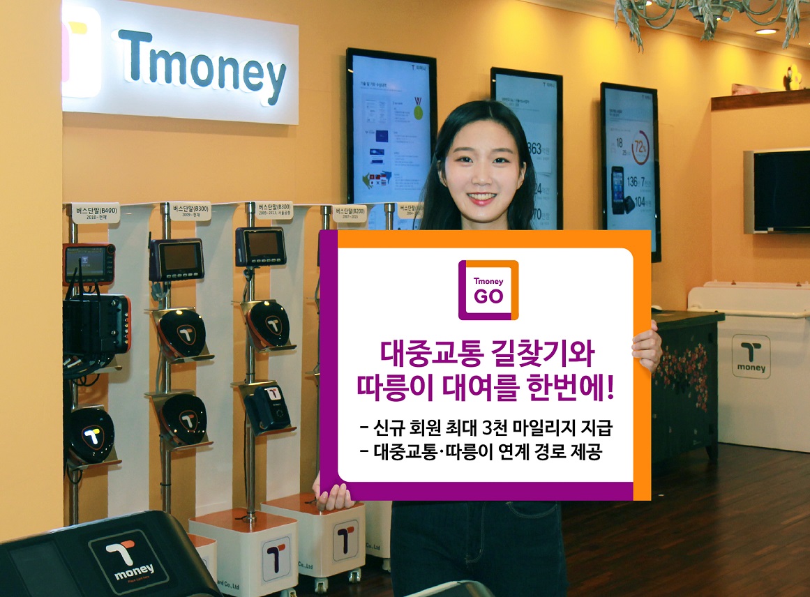 Tmoney GO. 대중교통 길찾기와 따릉이 대여를 한번에! -신규 회원 최대 3천 마일리지 지급 -대중교통·따릉이 연계 경로 제공. 팻말을 들고 있는 홍보대사