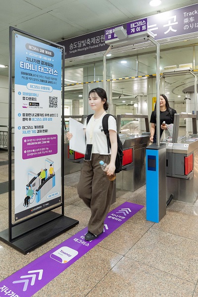 양손에 짐이 있는 인천 지하철 시민이 티머니 태그리스를 이용 중