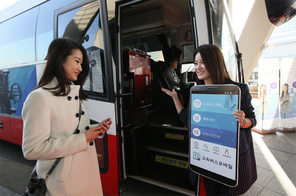 고속버스모바일 앱 화면 피켓을 들고 있는 여자가 버스 앞에서 탑승하는 승객에게 안내하는 장면